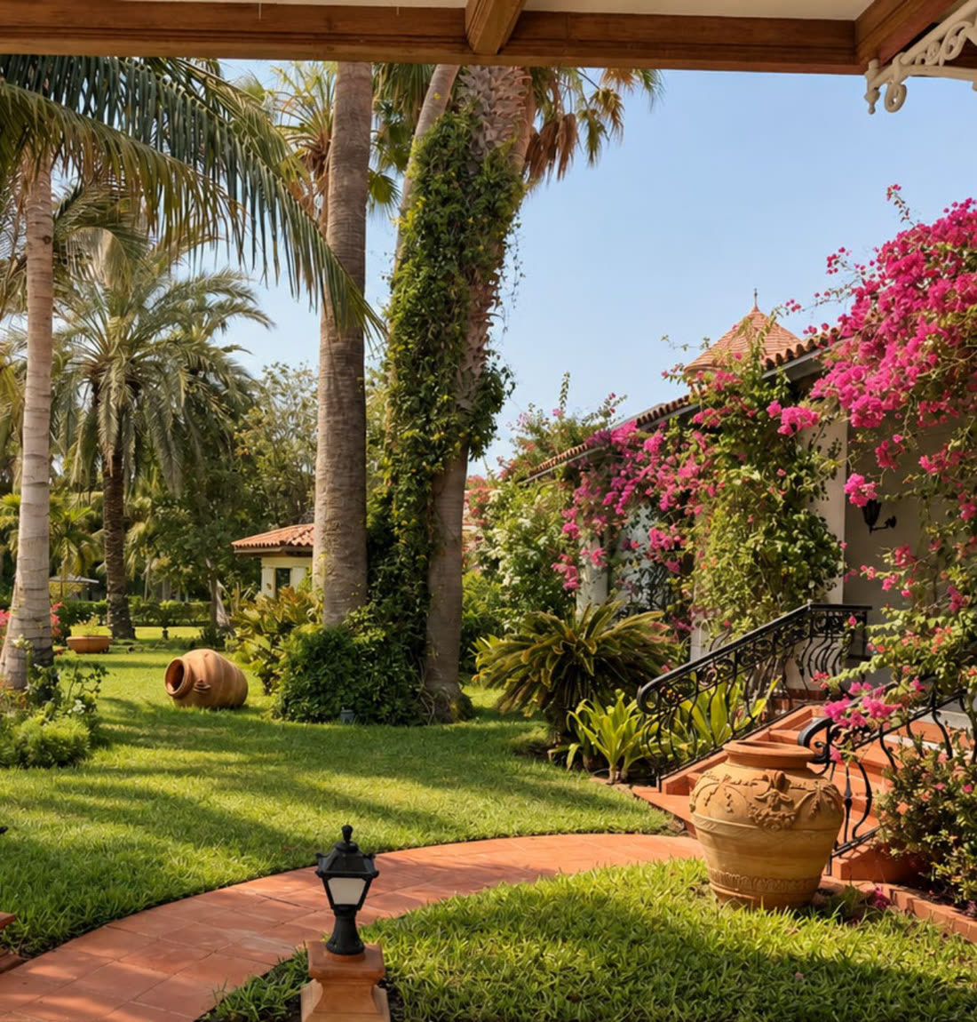 A villa terrace with bougainvillea, lawn and palms
